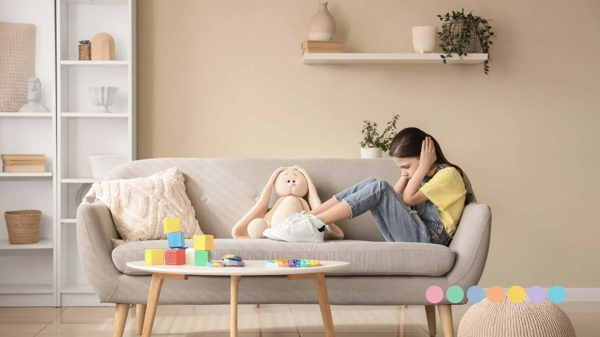 Devojčica sa autizmom pokazuje senzornu preplavljenost i pokriva uši rukama u mirnom kućnom okruženju.