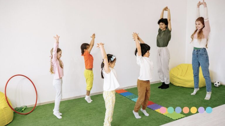 Grupa dece i dve odrasle osobe rade vežbe u zatvorenom prostoru, prikaz organizovanih aktivnosti i igre za decu.