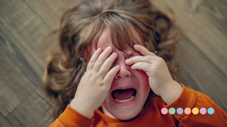 Malo dete leži na podu i plače, prekriva oči rukama, u stanju uzmenirenosti i jakih emocija, dok mu je lice crveno od suza.
