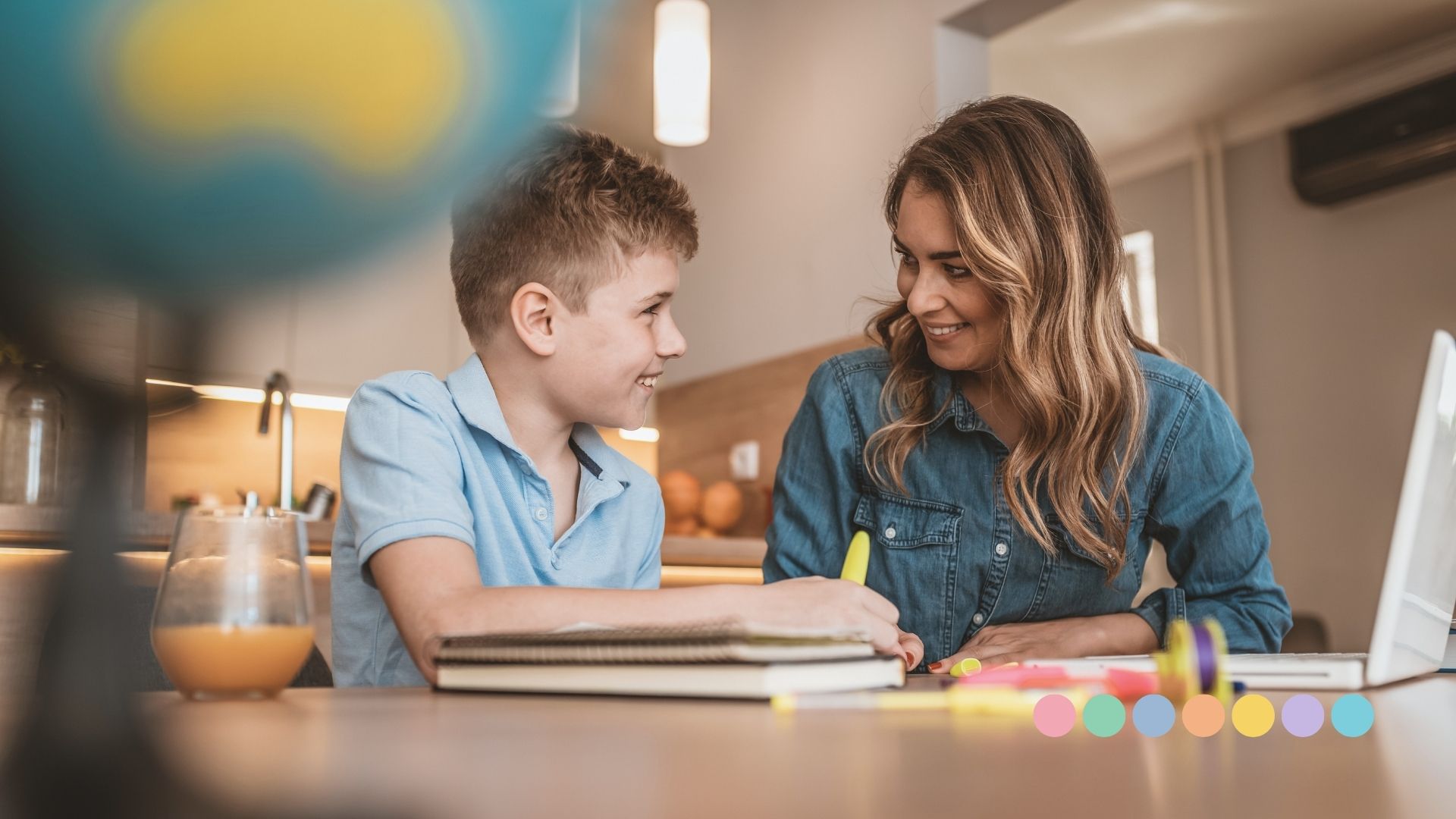 Majka i dečak zajedno rade domaći zadatak za stolom, prikaz podrške i primene strategije „prvo-posle“ u učenju i ponašanju