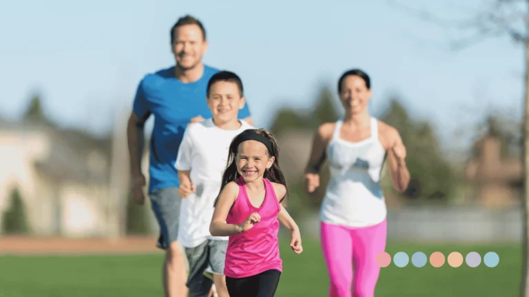 Četvoročlana porodica u sportskoj odeći trči zajedno po travi, sa devojčicom u roze majici u prvom planu koja se smeje, ilustrujući priču roditelja kao supermaraton bez usporavanja u borbi sa autizmom.